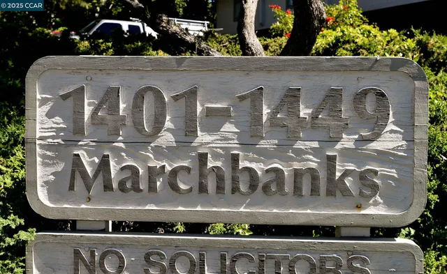 a view of a house with wooden fence and potted plants