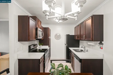 a kitchen with stainless steel appliances a sink stove and refrigerator