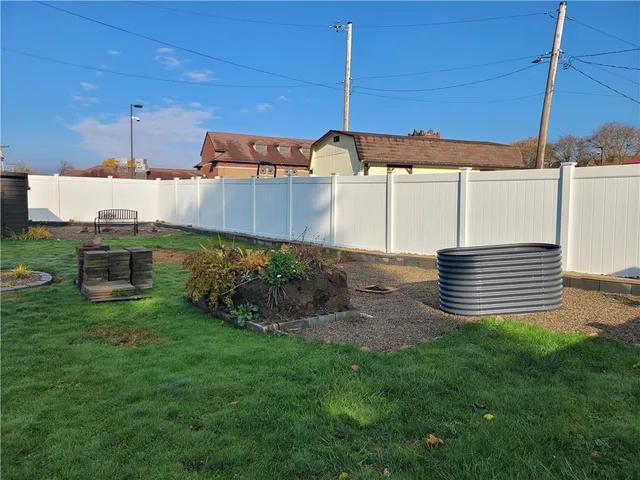 a backyard of a house with a garden and barbeque oven