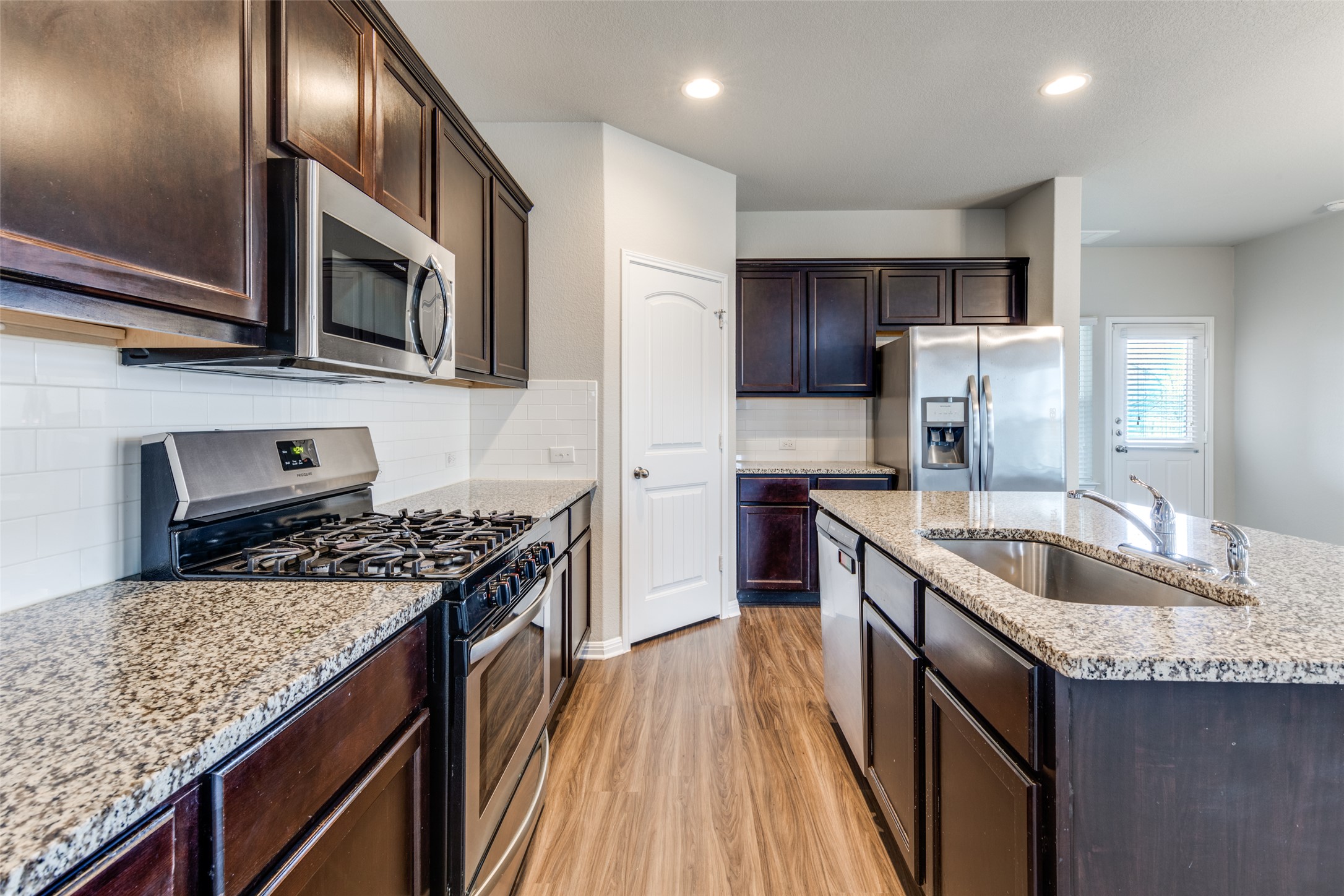 348 Shiner Lane Georgetown, TX 78626 - Photo 11 of 37 a kitchen with stainless steel appliances granite countertop a sink stove and refrigerator