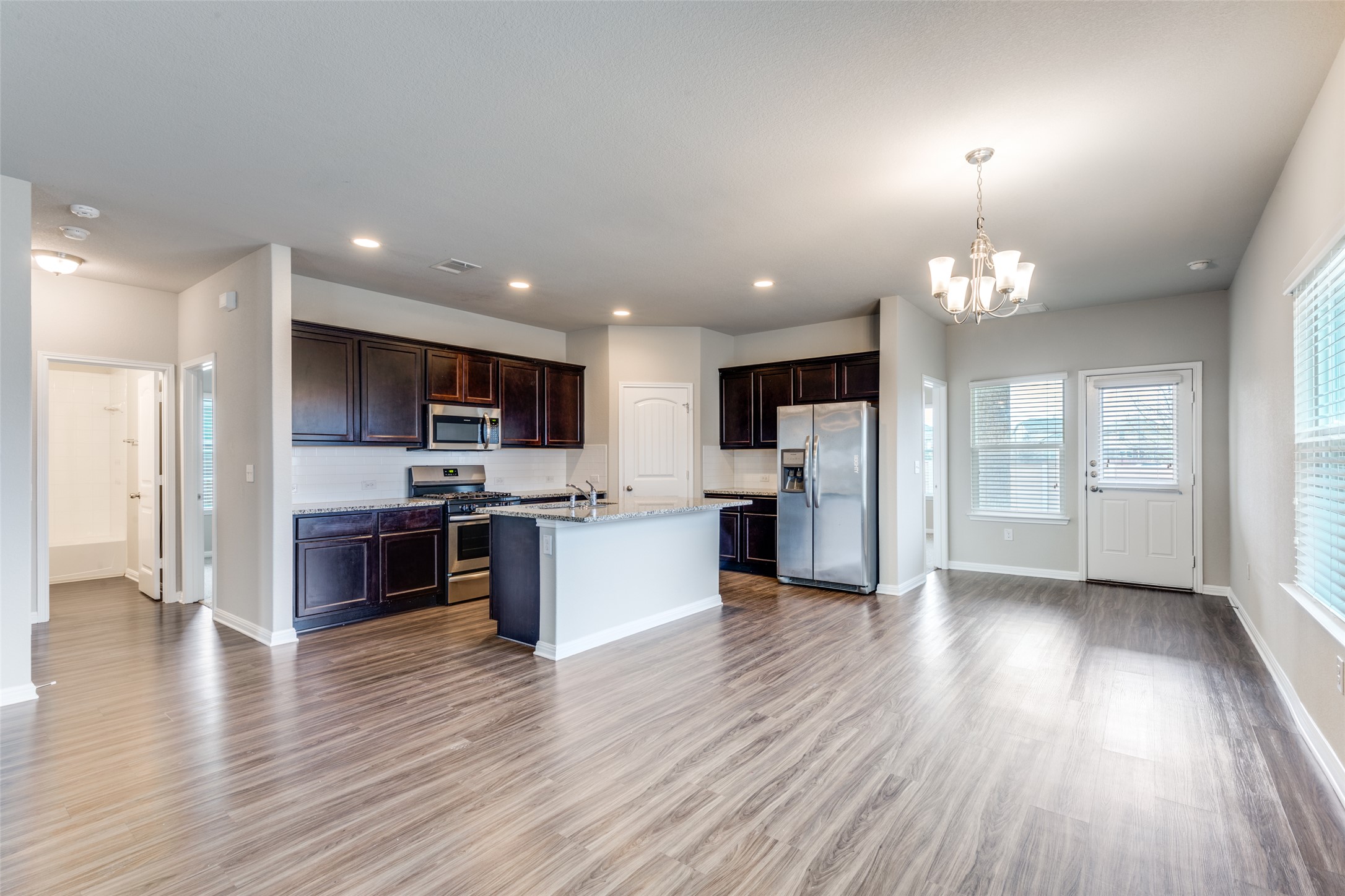 348 Shiner Lane Georgetown, TX 78626 - Photo 14 of 37 a large open kitchen with a refrigerator a stove a sink and a microwave
