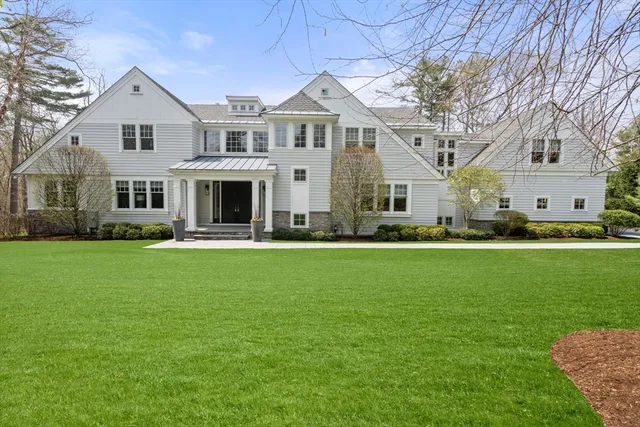 a front view of a house with a garden and trees