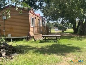 1104 Rorem Avenue Palacios, TX 77465 - Photo 3 of 17 a backyard of a house with a garden and outdoor seating