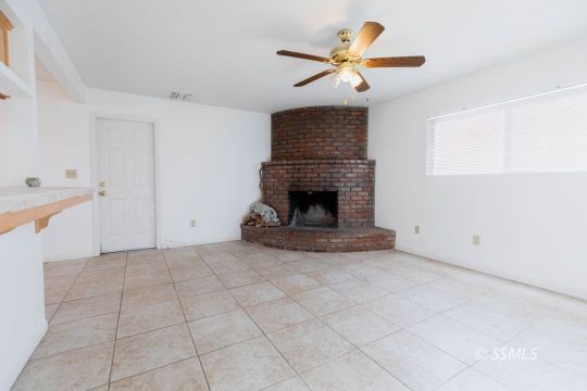 929 South Ranger Street Ridgecrest, CA 93555 - Photo 13 of 25 a view of an empty room with a fireplace and a window