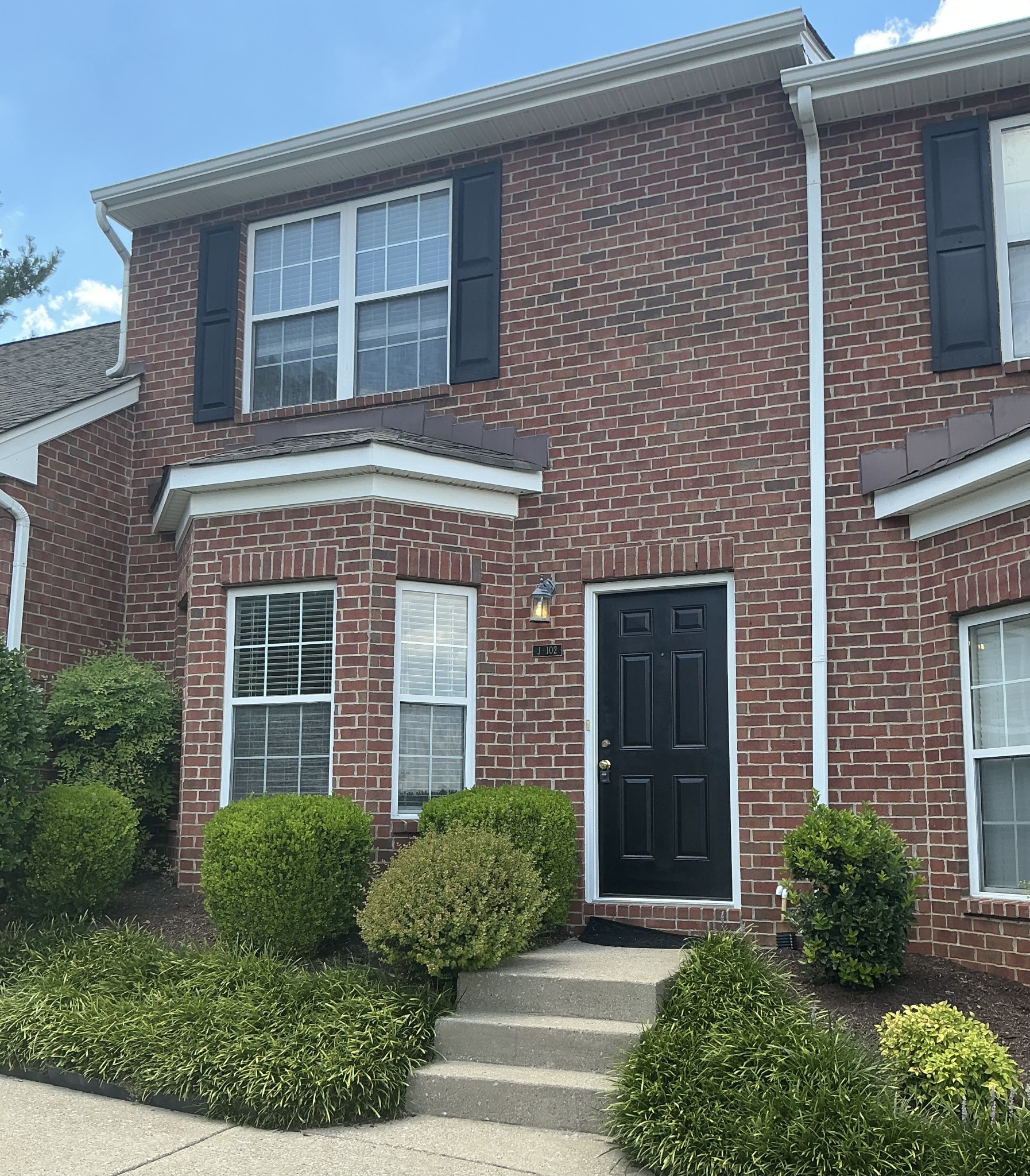 a front view of a brick house with a yard
