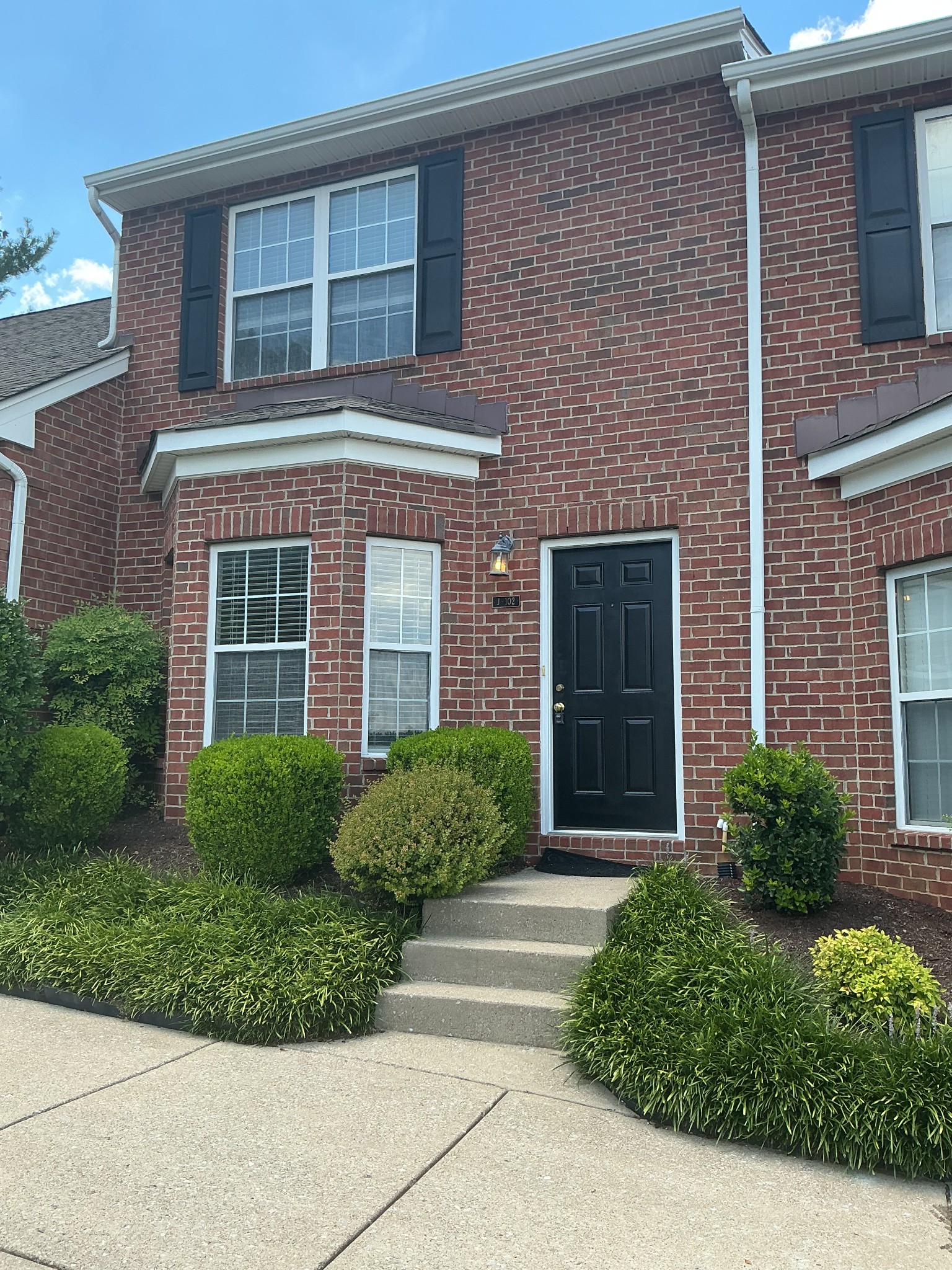 1101 Downs Boulevard, Unit J102 Franklin, TN 37064 - Photo 20 of 21 a view of brick house with a large windows and flower plants