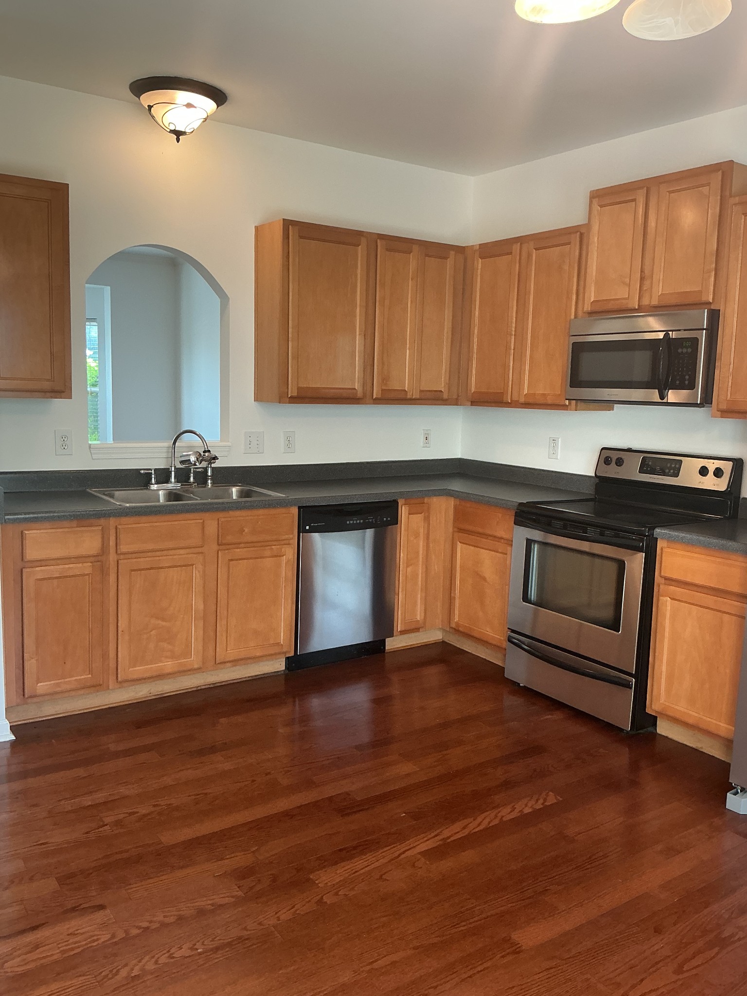 1101 Downs Boulevard, Unit J102 Franklin, TN 37064 - Photo 2 of 21 a kitchen with granite countertop a stove a sink and a microwave