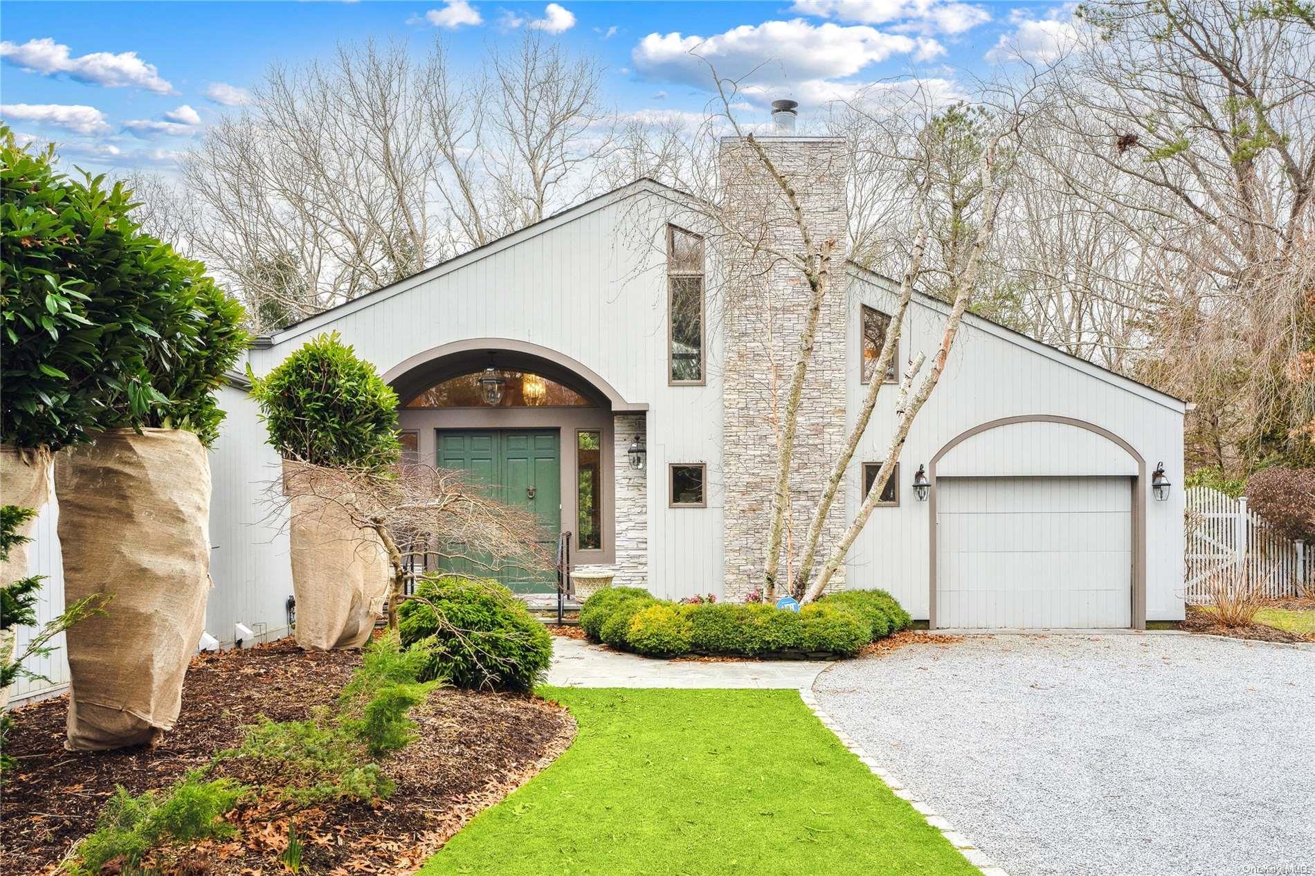 23 Pheasant Run Quogue, NY 11959 - Photo 1 of 1 a front view of a house with a garden and plants