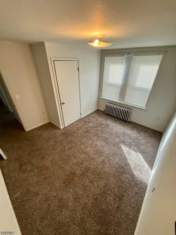 a view of a livingroom with an empty space and a window
