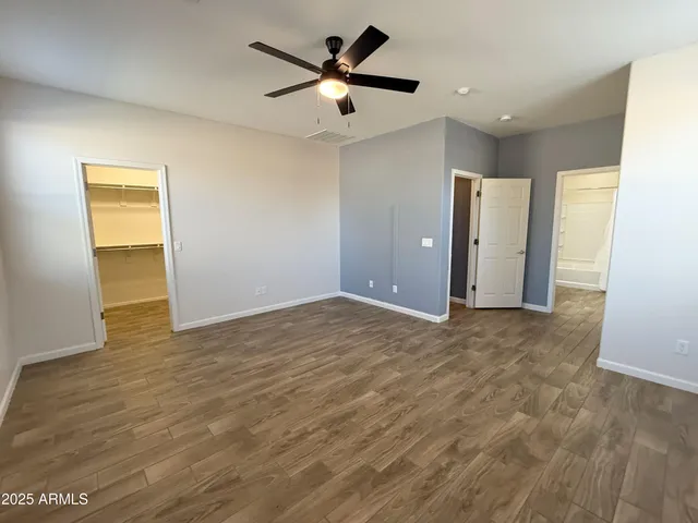 a view of a livingroom with a ceiling fan & hardwood floor