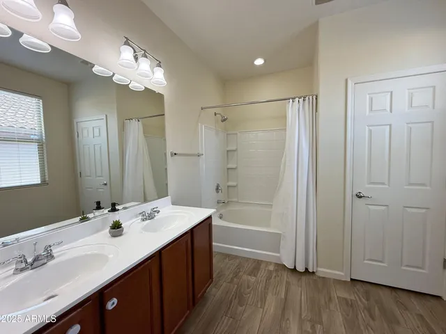 a bathroom with a double vanity sink a large mirror and shower