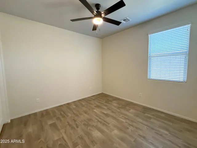 an empty room with a window and a ceiling fan