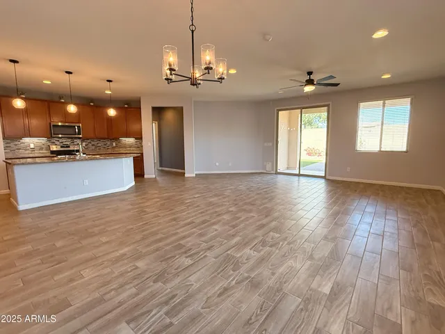 a view of a big room with wooden floor and windows