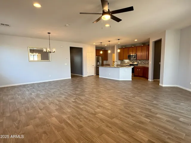a view of a kitchen with kitchen island wooden floor center island and stainless steel appliances