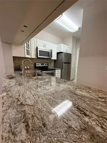 a kitchen with stainless steel appliances a refrigerator sink microwave and cabinets