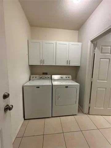 a utility room with cabinets washer and dryer
