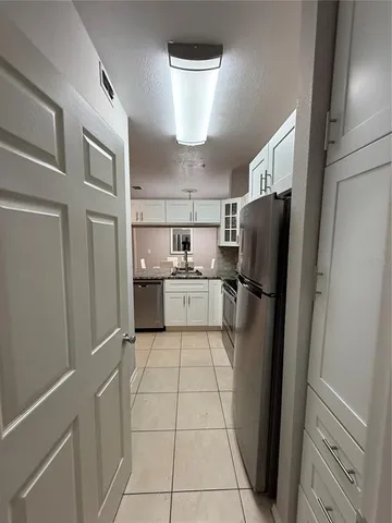 a kitchen with stainless steel appliances a refrigerator sink and cabinets