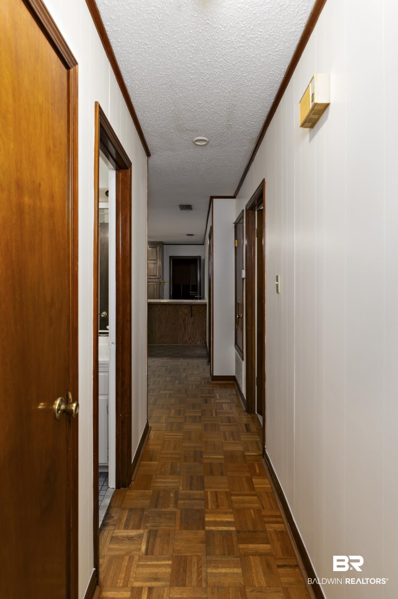 707 Johnson Avenue Fairhope, AL 36532 - Photo 21 of 38 Hallway featuring visible vents, a textured ceiling, baseboards, and ornamental molding