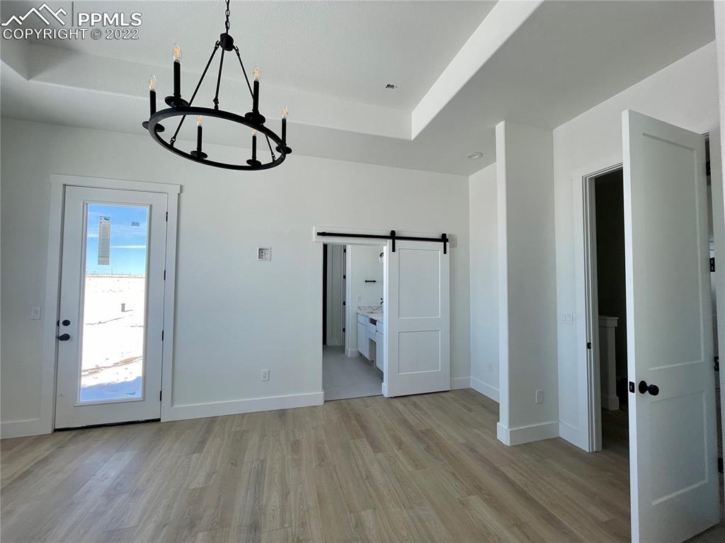 8350 Howdy Partner View Peyton, CO 80831 - Photo 5 of 14 a view of a hallway with wooden floor and chandelier