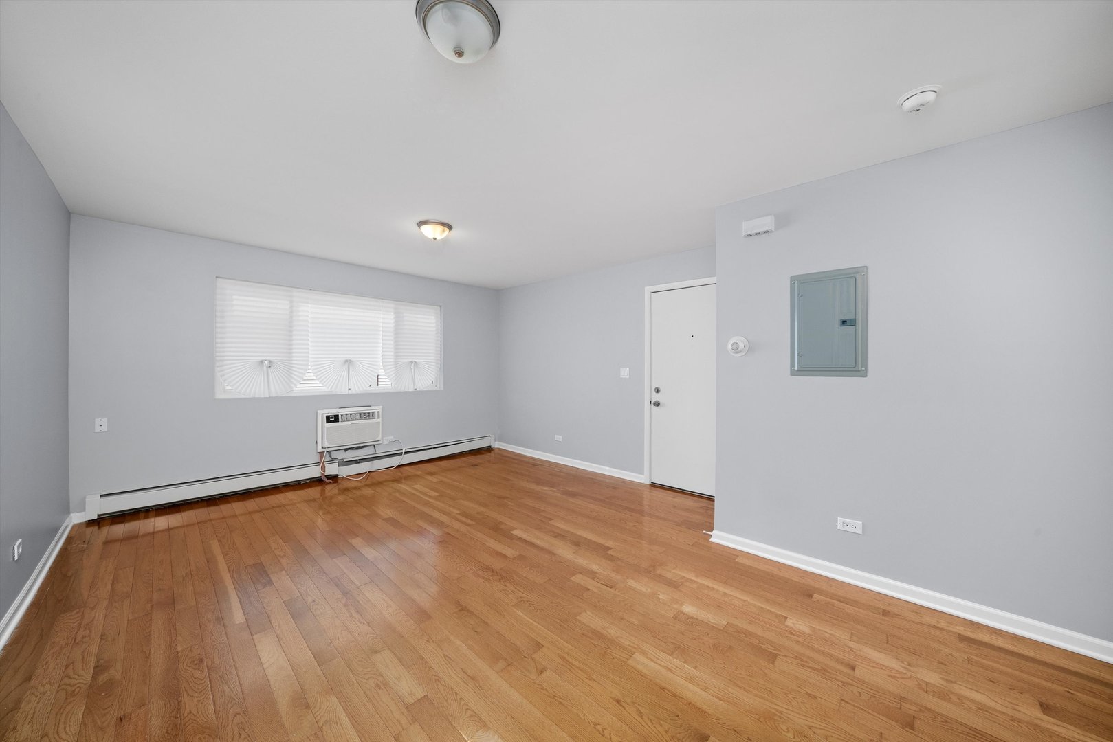 327 Wisconsin Avenue, Unit 5B Oak Park, IL 60302 - Photo 5 of 18 a view of an empty room with wooden floor and a window