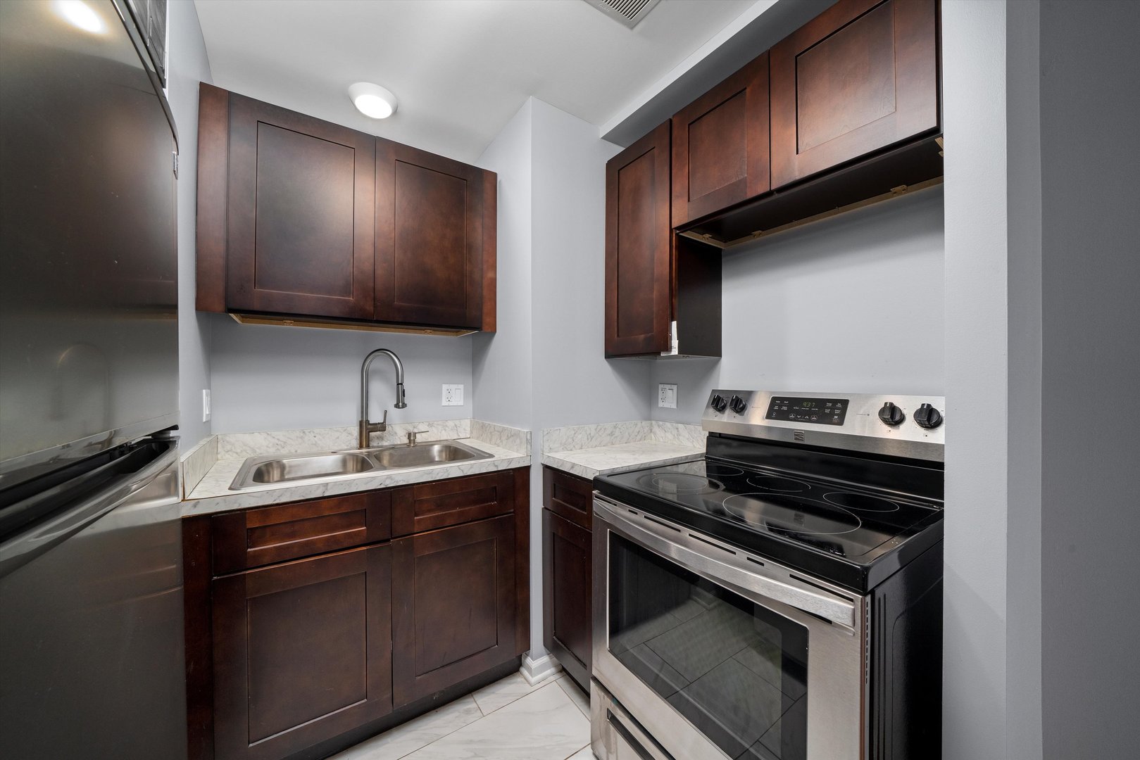 327 Wisconsin Avenue, Unit 5B Oak Park, IL 60302 - Photo 7 of 18 a kitchen with a sink stove and cabinets
