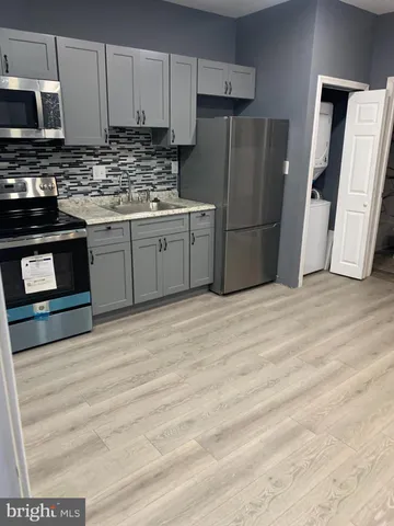 a kitchen with stainless steel appliances a stove a refrigerator and a sink