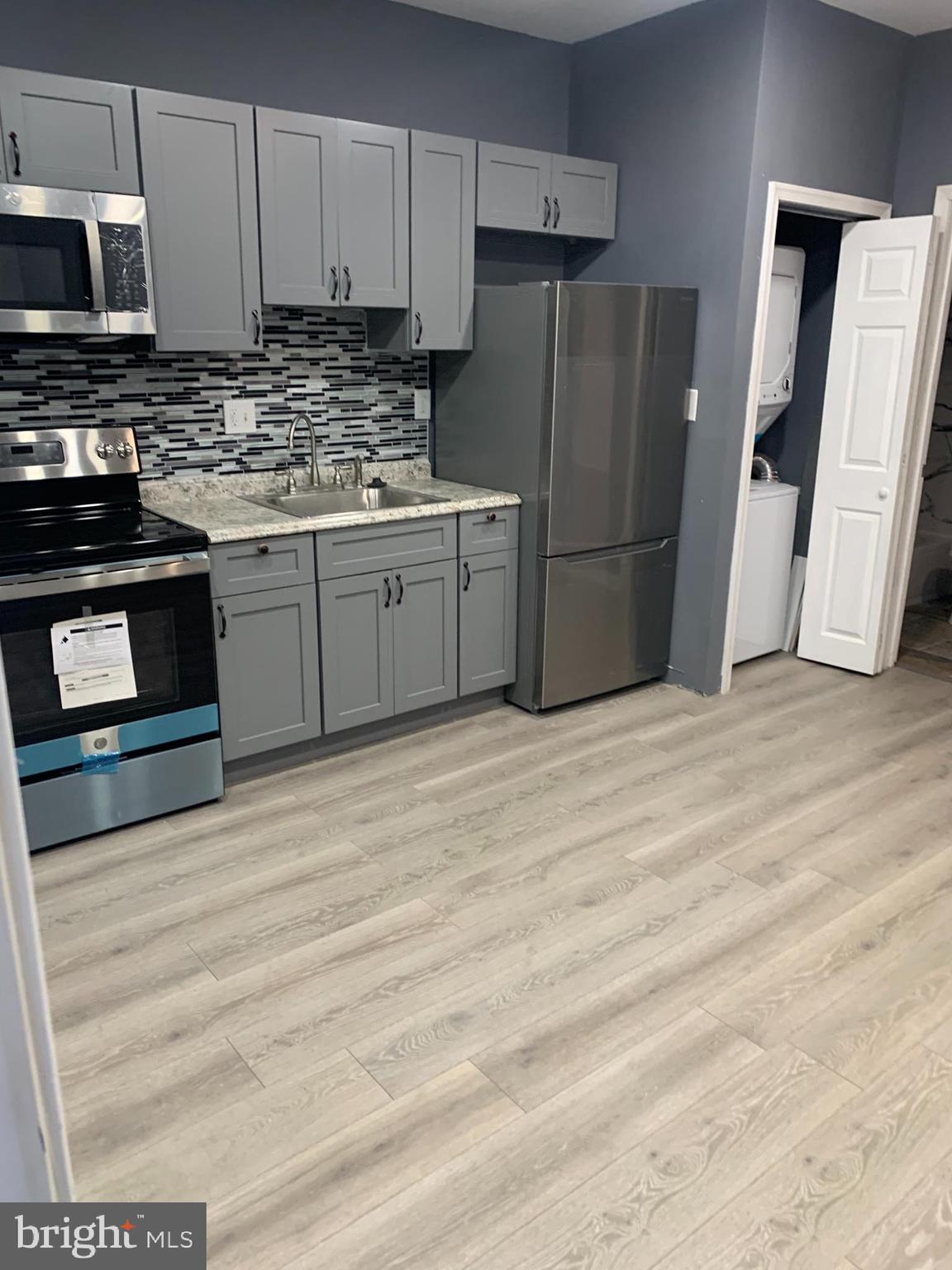 a kitchen with stainless steel appliances a stove a refrigerator and a sink