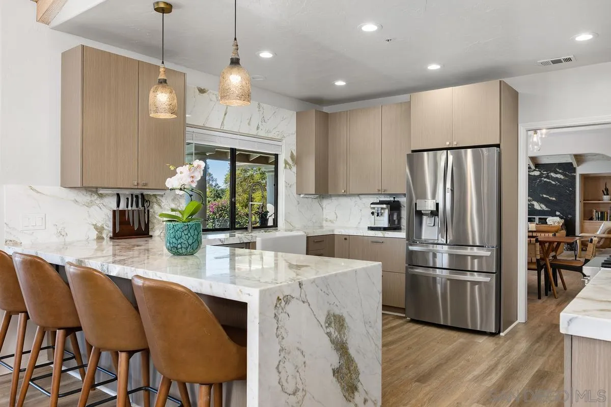 3064 Live Oak Park Road Fallbrook, CA 92028 - Photo 11 of 74 a kitchen with stainless steel appliances granite countertop a refrigerator a sink a stove a dining table and chairs