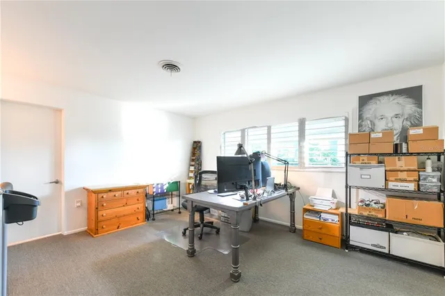 a view of a livingroom with workspace and a window