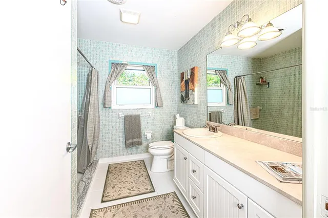 a spacious bathroom with a granite countertop sink a toilet and shower
