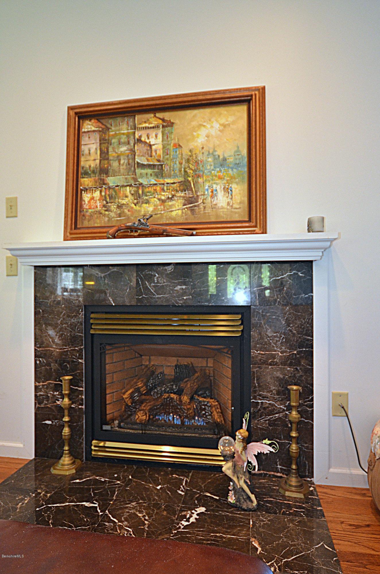 1381 East Otis Road Otis, MA 01029 - Photo 12 of 48 a fireplace with a clock on top of it
