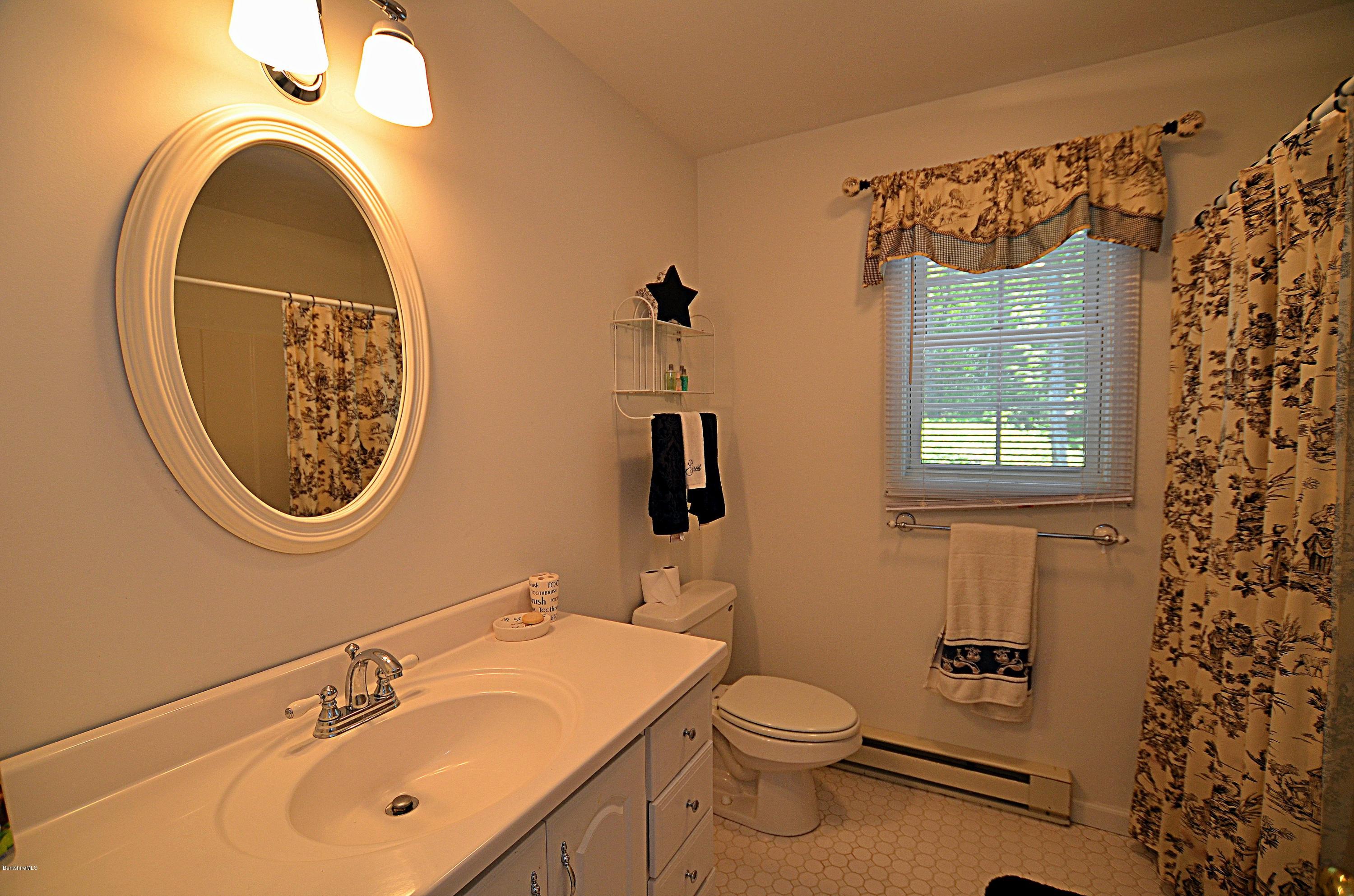 1381 East Otis Road Otis, MA 01029 - Photo 32 of 48 a bathroom with a toilet a sink and mirror