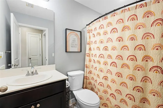 a bathroom with a sink and mirror with toilet