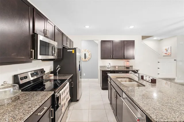 a kitchen with granite countertop stainless steel appliances and wooden cabinets