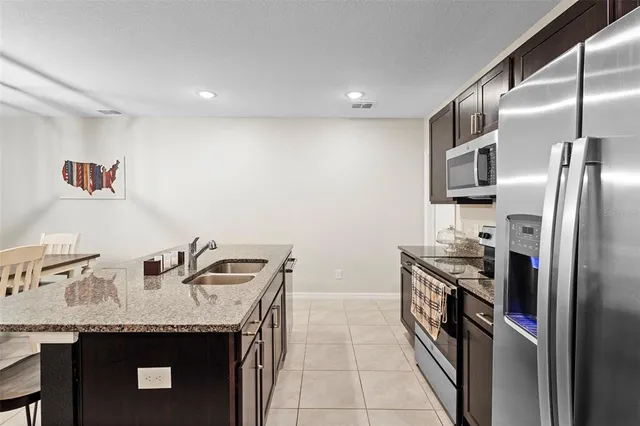 a kitchen with granite countertop a sink stove and refrigerator