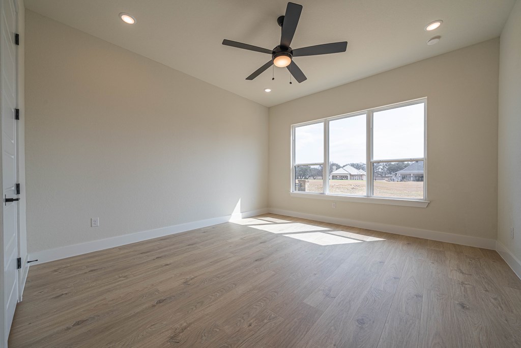 2013 Toscano Way Kerrville, TX 78028 - Photo 12 of 17 an empty room with wooden floor fan and windows