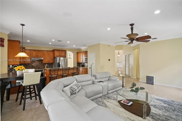 a living room with furniture a chandelier and a dining table