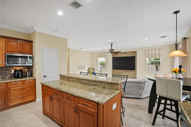 a view of kitchen island with stainless steel appliances granite countertop living room