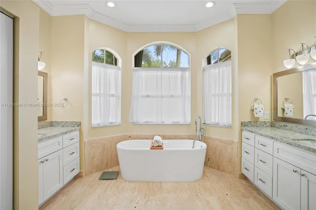 a bathroom with a tub a double vanity sink and mirror