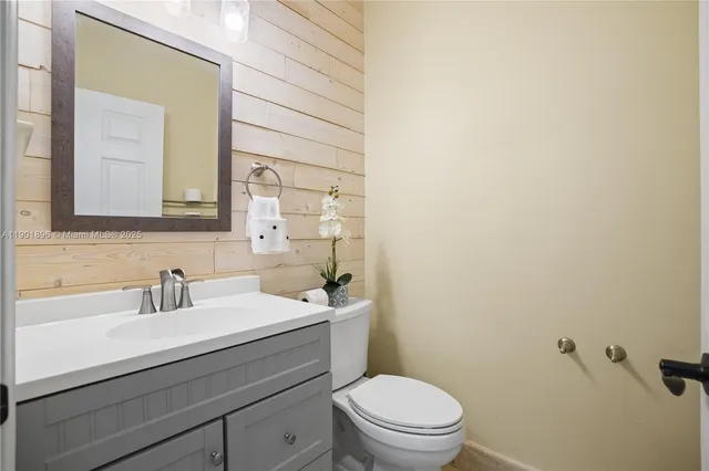 a bathroom with a sink a toilet a mirror and shower