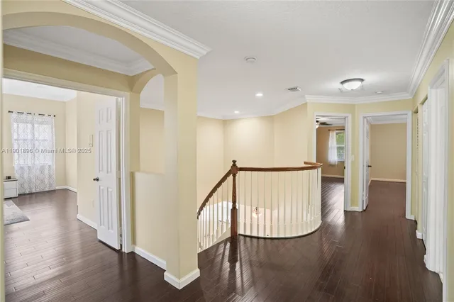 a view of a hallway with wooden floor and staircase
