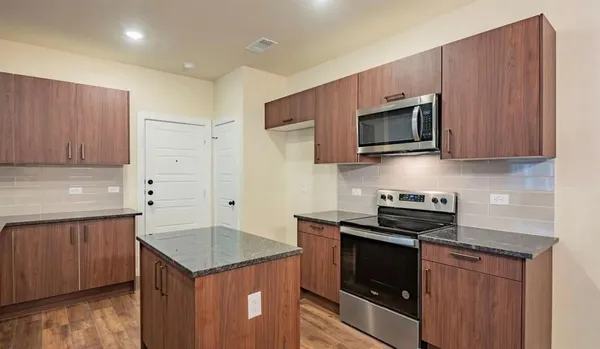 a kitchen with stainless steel appliances a stove microwave and cabinets