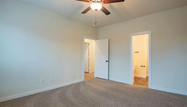 an empty room with a ceiling fan and a window