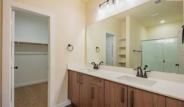 a bathroom with a double vanity sink and mirror