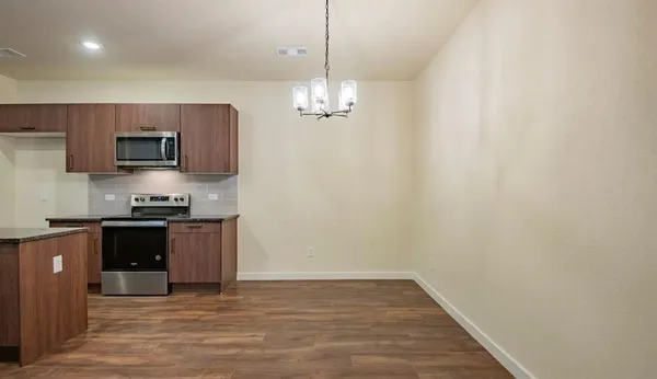 a kitchen with stainless steel appliances granite countertop a refrigerator a stove top oven a sink and dishwasher