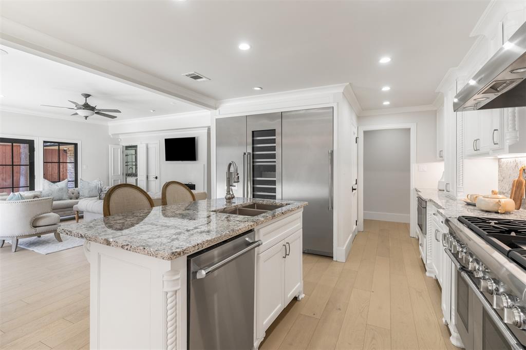 3922 Inwood Road Dallas, TX 75209 - Photo 9 of 35 a kitchen with stainless steel appliances granite countertop a stove top oven a sink dishwasher a dining table and chairs with wooden floor
