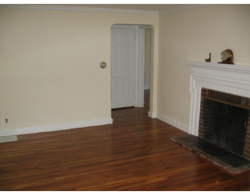 53 Pierrepont Road Newton, MA 02462 - Photo 4 of 13 a view of an empty room with wooden floor and a fireplace