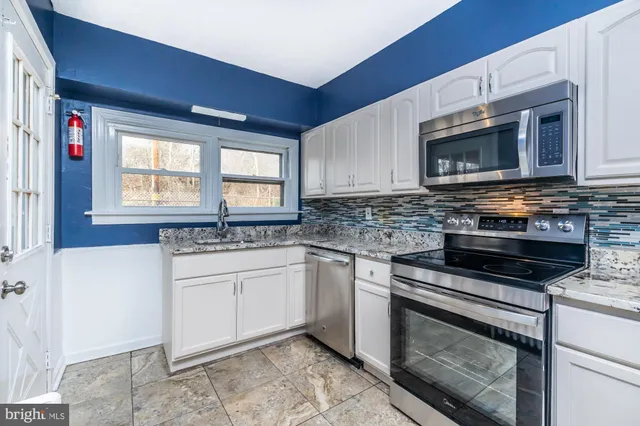 a kitchen with stainless steel appliances granite countertop a stove microwave and sink