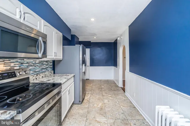 a kitchen with stainless steel appliances granite countertop a refrigerator and a stove top oven