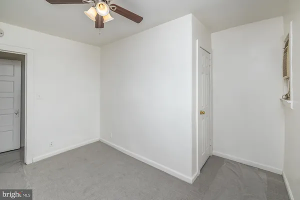 an empty room with a chandelier fan